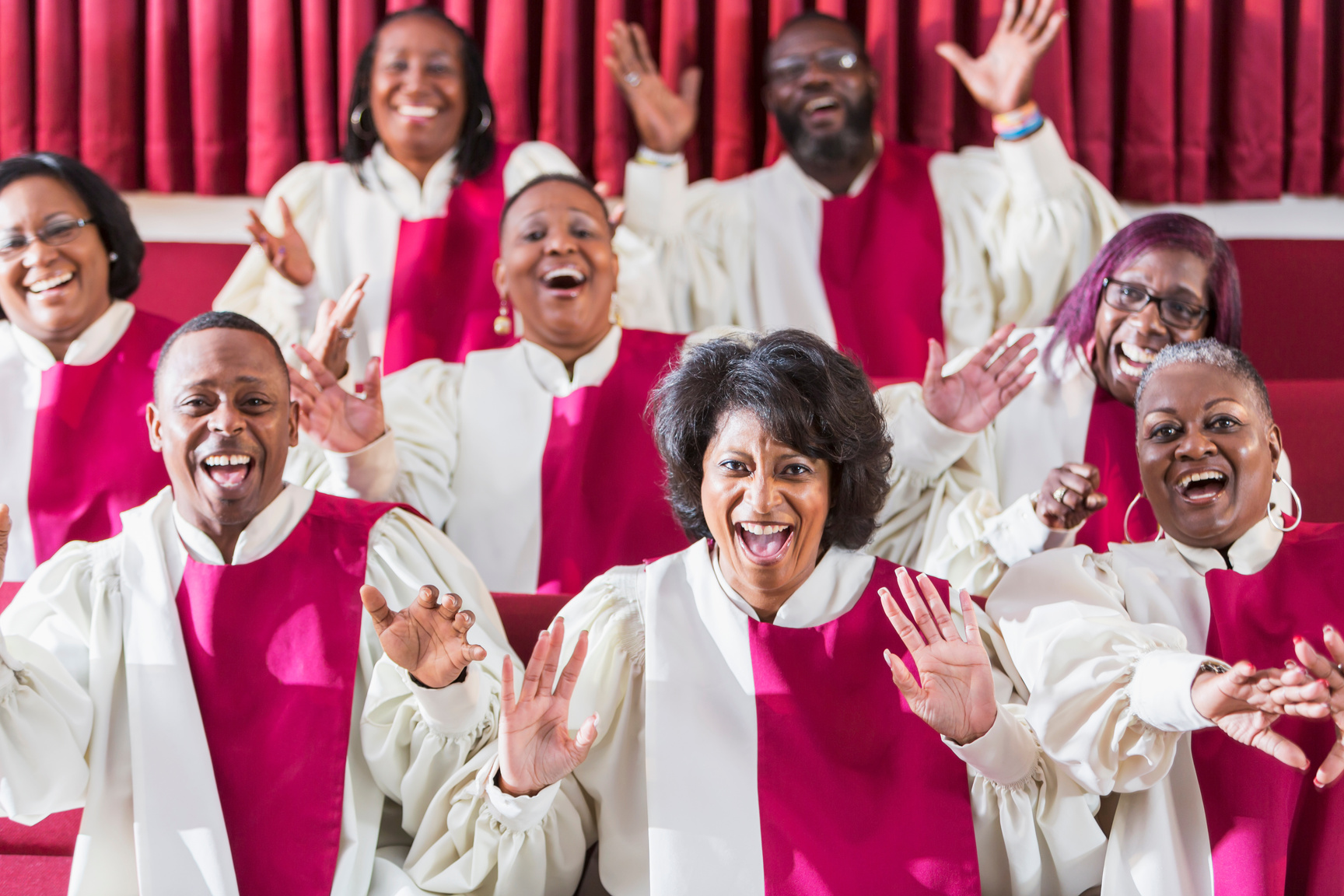 Mature black women and men singing in church choir